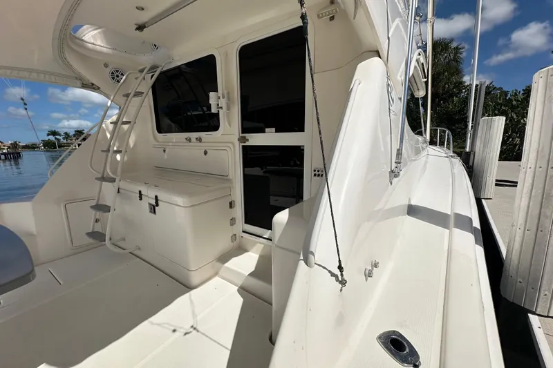 Game On Yacht Photos Pics 2002 Riviera 40 Flybridge yacht deck with ladder and storage, docked by water.