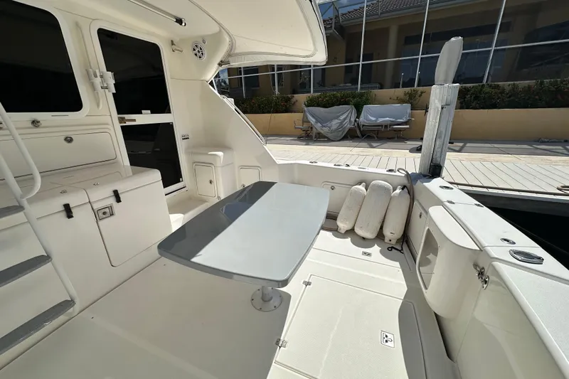 Game On Yacht Photos Pics 2002 Riviera 40 Flybridge yacht interior with seating, table, and dock view.