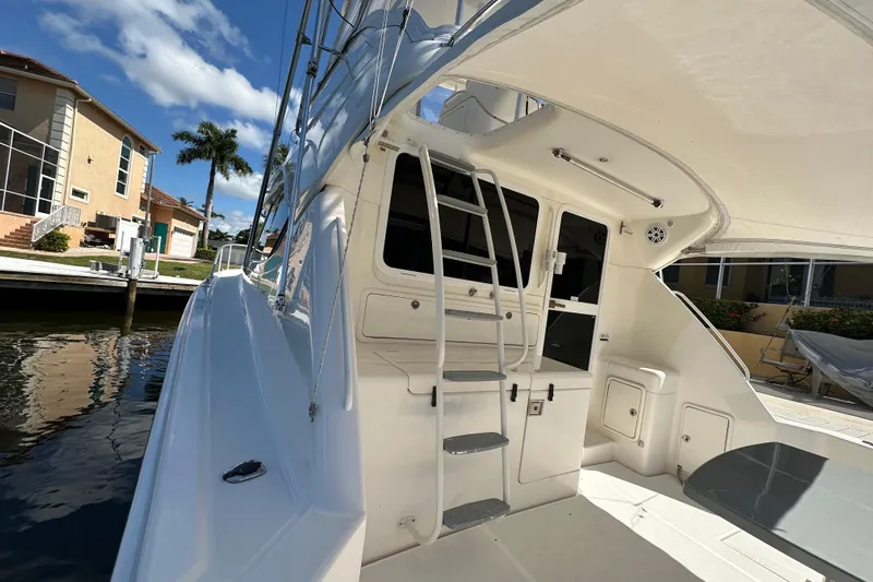 Game On Yacht Photos Pics 2002 Riviera 40 Flybridge yacht docked, showcasing sleek design and spacious deck area.