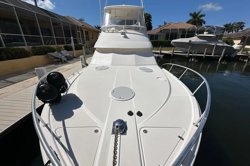 Game On Yacht Photos Pics 2002 Riviera 40 Flybridge yacht docked, showcasing spacious deck and sleek design.