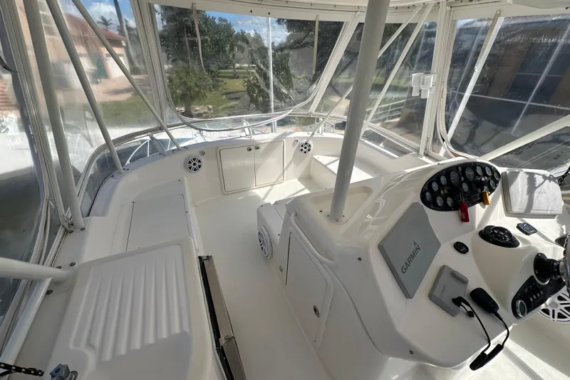 Game On Yacht Photos Pics 2002 Riviera 40 Flybridge helm with Garmin navigation, enclosed by clear panels.