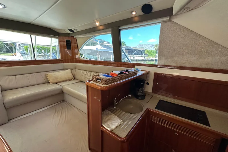 Game On Yacht Photos Pics Luxurious interior of 2002 Riviera 40 Flybridge yacht with leather seating and kitchenette.