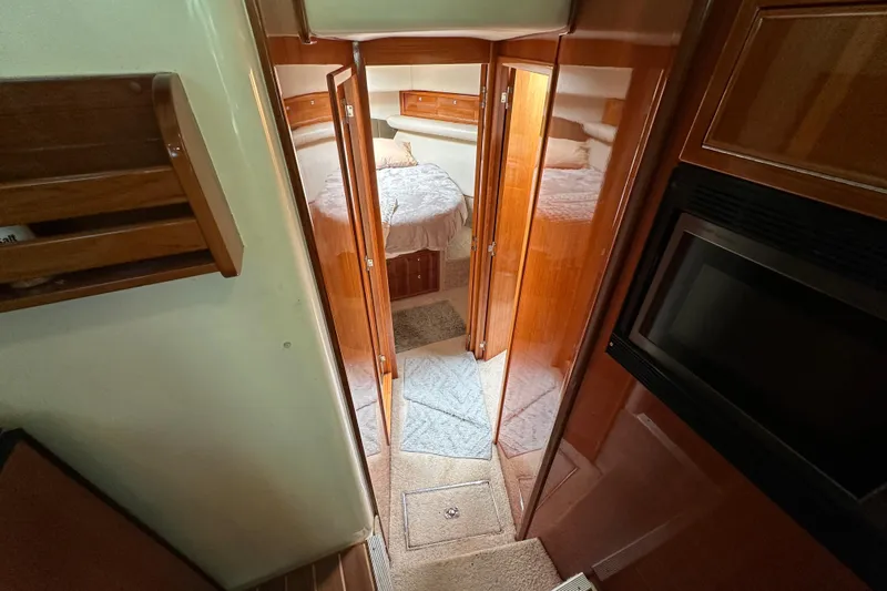 Game On Yacht Photos Pics Interior of 2002 Riviera 40 Flybridge yacht with cozy cabin and wooden finishes.