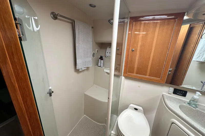 Game On Yacht Photos Pics Bathroom interior of 2002 Riviera 40 Flybridge yacht with shower and wooden cabinetry.