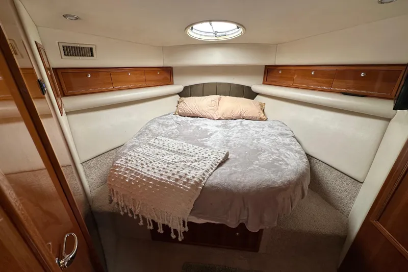 Game On Yacht Photos Pics Cozy bedroom in 2002 Riviera 40 Flybridge yacht with plush bedding and wooden storage.