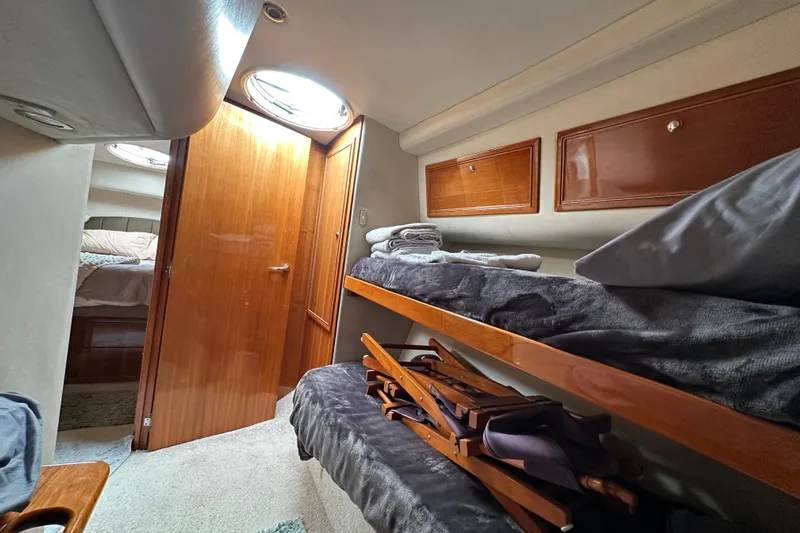 Game On Yacht Photos Pics Interior of 2002 Riviera 40 Flybridge yacht with cozy bunk beds and wooden cabinetry.