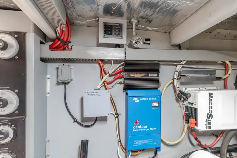 Jolie Vie Yacht Photos Pics Electrical system inside a 2004 Meridian 540 Pilothouse, featuring wiring and battery chargers.