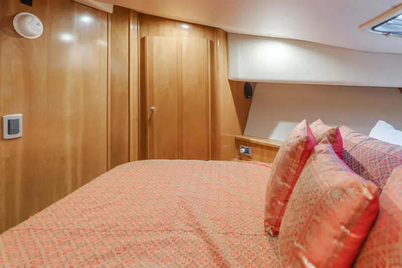 Jolie Vie Yacht Photos Pics Luxurious bedroom interior of 2004 Meridian 540 Pilothouse yacht with elegant wood paneling.