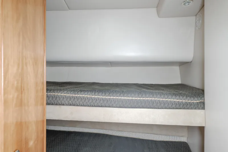 Jolie Vie Yacht Photos Pics Bunk beds in 2004 Meridian 540 Pilothouse yacht cabin, featuring wood paneling and cozy bedding.