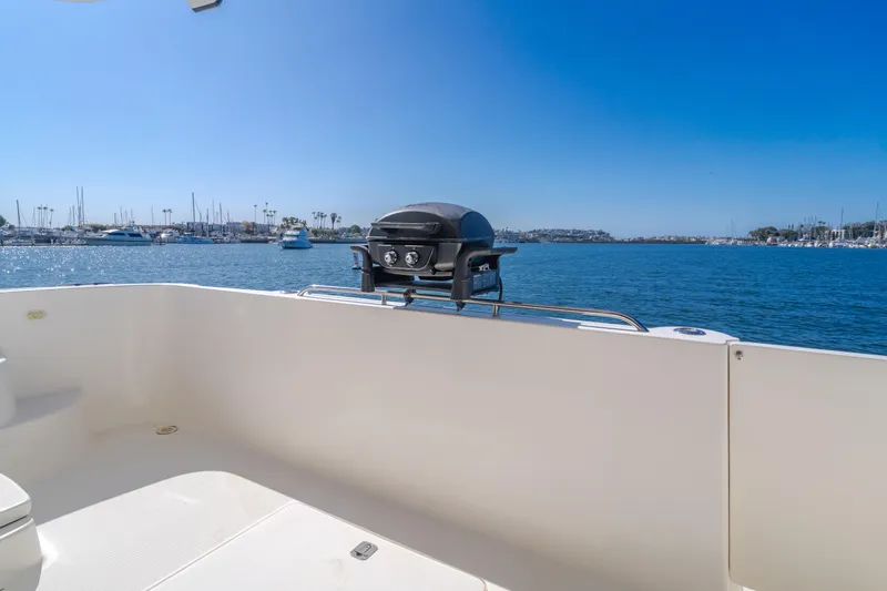 Jolie Vie Yacht Photos Pics 2004 Meridian 540 Pilothouse yacht deck with grill, overlooking marina and blue sea.