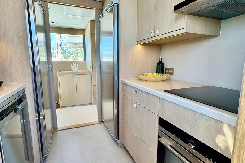  Yacht Photos Pics Modern kitchen interior of 2026 Outer Reef Yachts 780 Adventure, featuring sleek appliances and wood cabinetry.