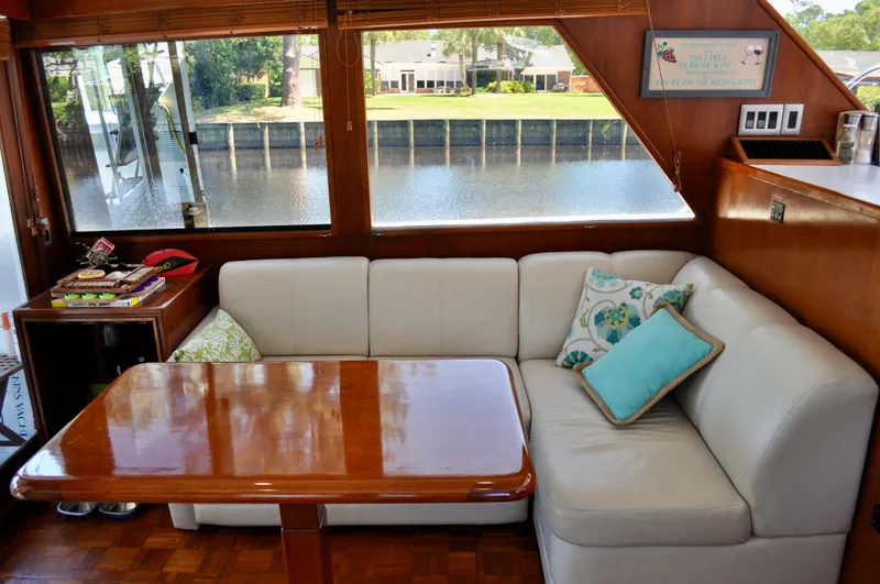 Freakin' Awesome Yacht Photos Pics Interior of 1990 Ocean Alexander 42 Sedan with white sofa and wooden table by large windows.