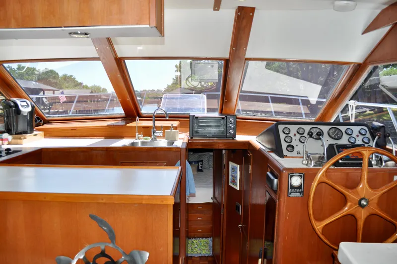 Freakin' Awesome Yacht Photos Pics 1990 Ocean Alexander 42 Sedan interior with wooden helm, kitchen, and panoramic windows.
