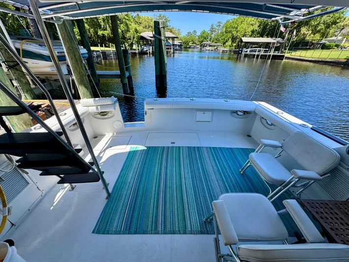 Freakin' Awesome Yacht Photos Pics 1990 Ocean Alexander 42 Sedan yacht deck with seating, blue rug, and scenic waterway view.