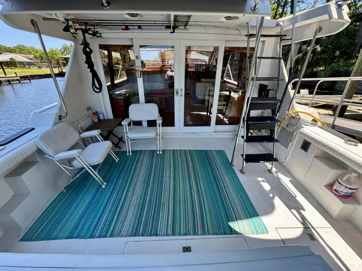 Freakin' Awesome Yacht Photos Pics 1990 Ocean Alexander 42 Sedan yacht deck with chairs and a striped rug.