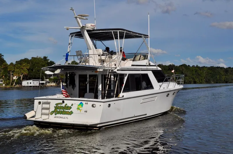 Freakin' Awesome Yacht Photos Pics 1990 Ocean Alexander 42 Sedan cruising on a scenic river.