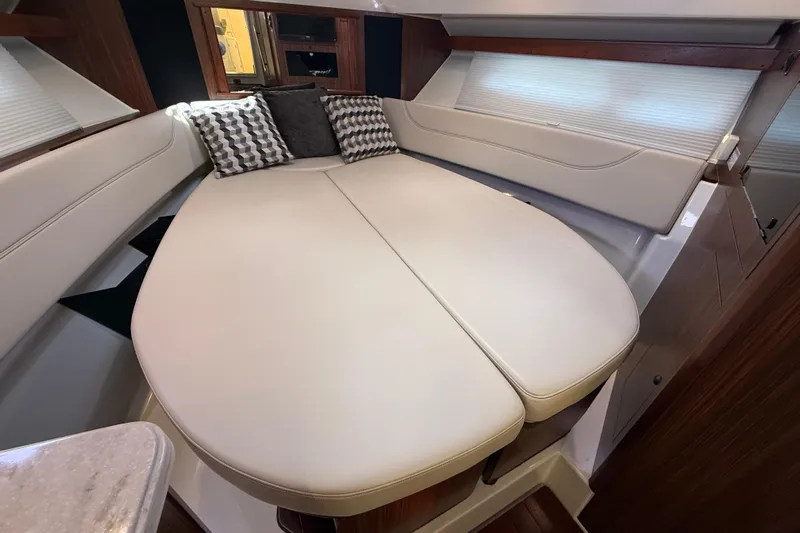 Bon Voyage Yacht Photos Pics Luxurious interior of 2019 Pursuit OS 355 Offshore boat with plush seating and cushions.