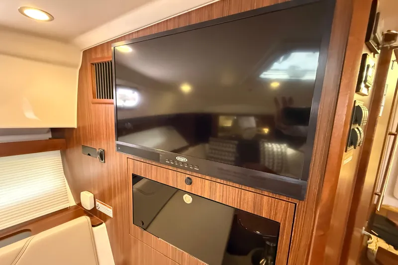 Bon Voyage Yacht Photos Pics Interior of 2019 Pursuit OS 355 Offshore with mounted TV and wood paneling.