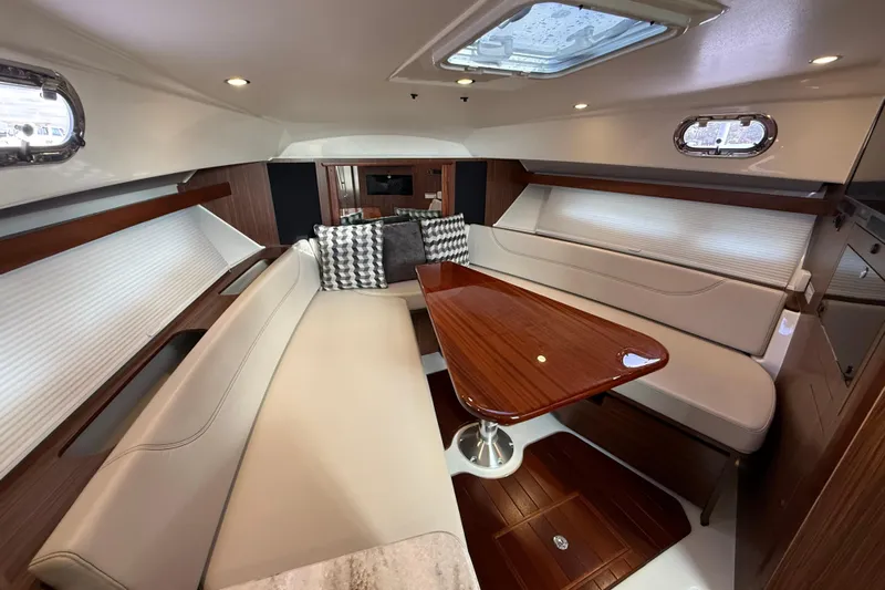 Bon Voyage Yacht Photos Pics Luxurious interior of 2019 Pursuit OS 355 Offshore yacht with elegant seating and wooden table.
