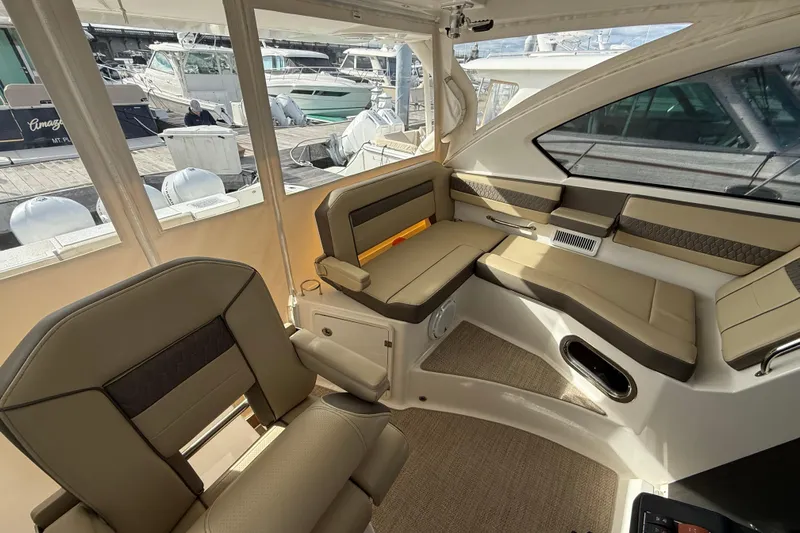 Bon Voyage Yacht Photos Pics Interior of 2019 Pursuit OS 355 Offshore boat with beige seating and marina view.