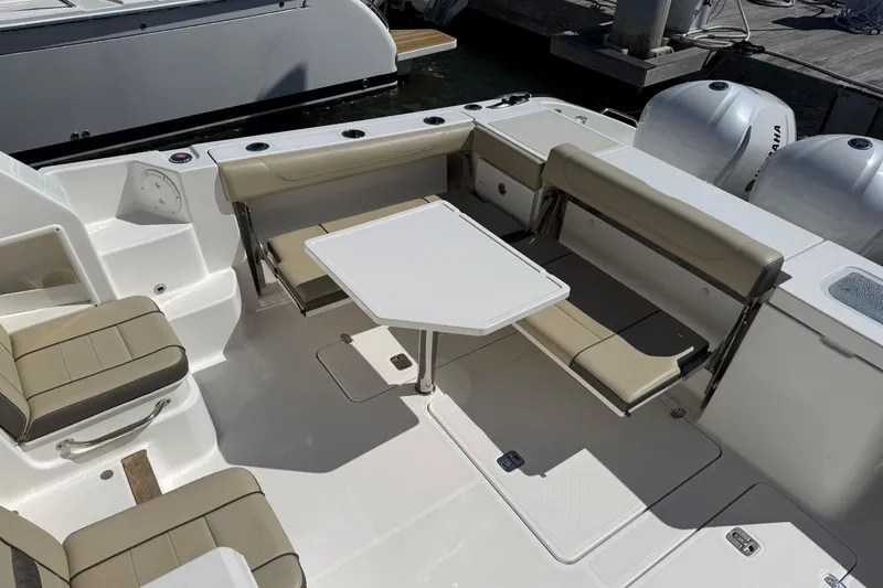 Bon Voyage Yacht Photos Pics 2019 Pursuit OS 355 Offshore boat interior with seating and table setup.