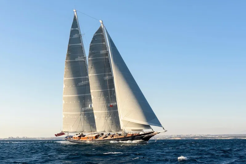 Meteor Yacht Photos Pics Elegant 2007 Royal Huisman Schooner sailing on open sea under clear blue sky.