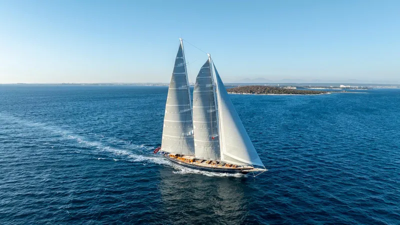 Meteor Yacht Photos Pics Aerial view of 2007 Royal Huisman Schooner sailing on open sea.