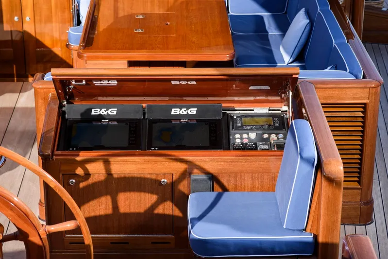Meteor Yacht Photos Pics Luxurious 2007 Royal Huisman Schooner cockpit with navigation equipment and blue cushioned seating.