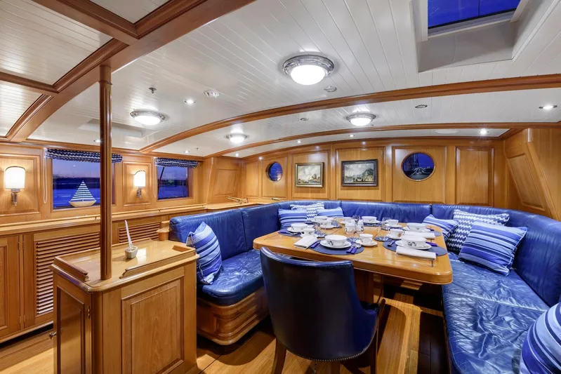 Meteor Yacht Photos Pics Luxurious 2007 Royal Huisman Schooner interior with elegant dining area and blue leather seating.