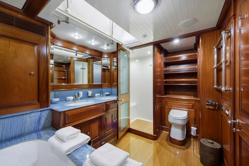 Meteor Yacht Photos Pics Luxurious wooden bathroom interior on 2007 Royal Huisman Schooner yacht, featuring elegant fixtures and blue accents.