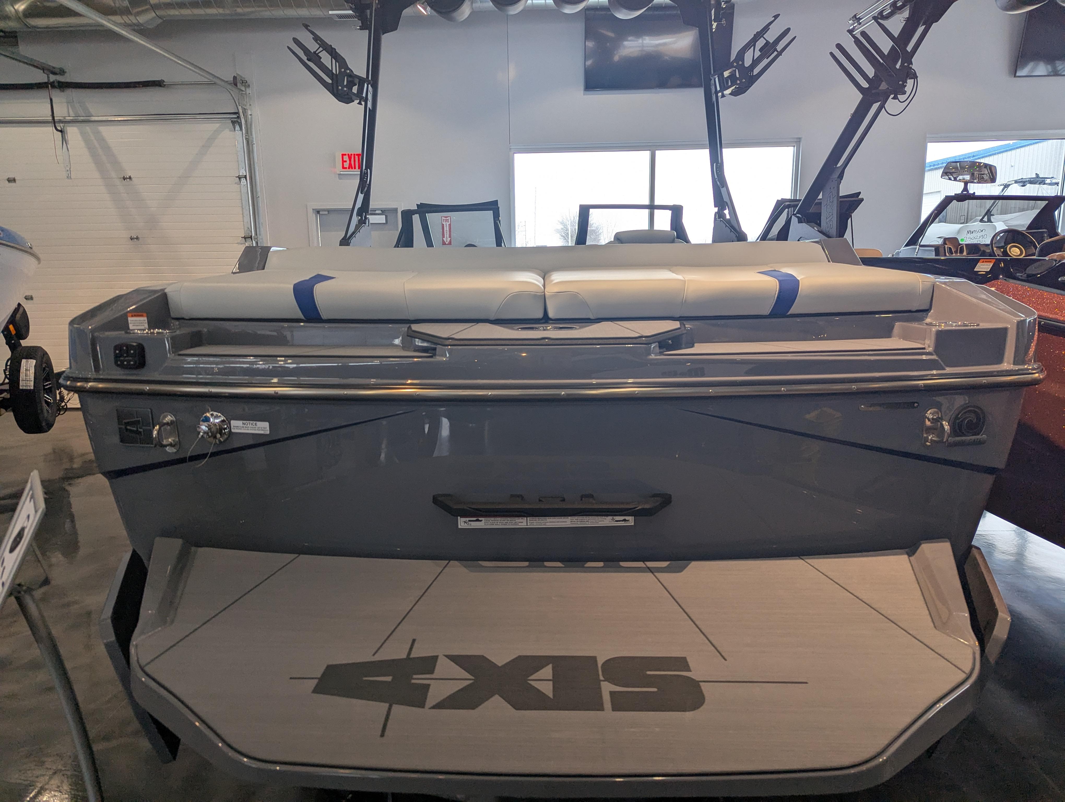 2025 Axis T220 boat in showroom, rear view with seating and logo visible.
