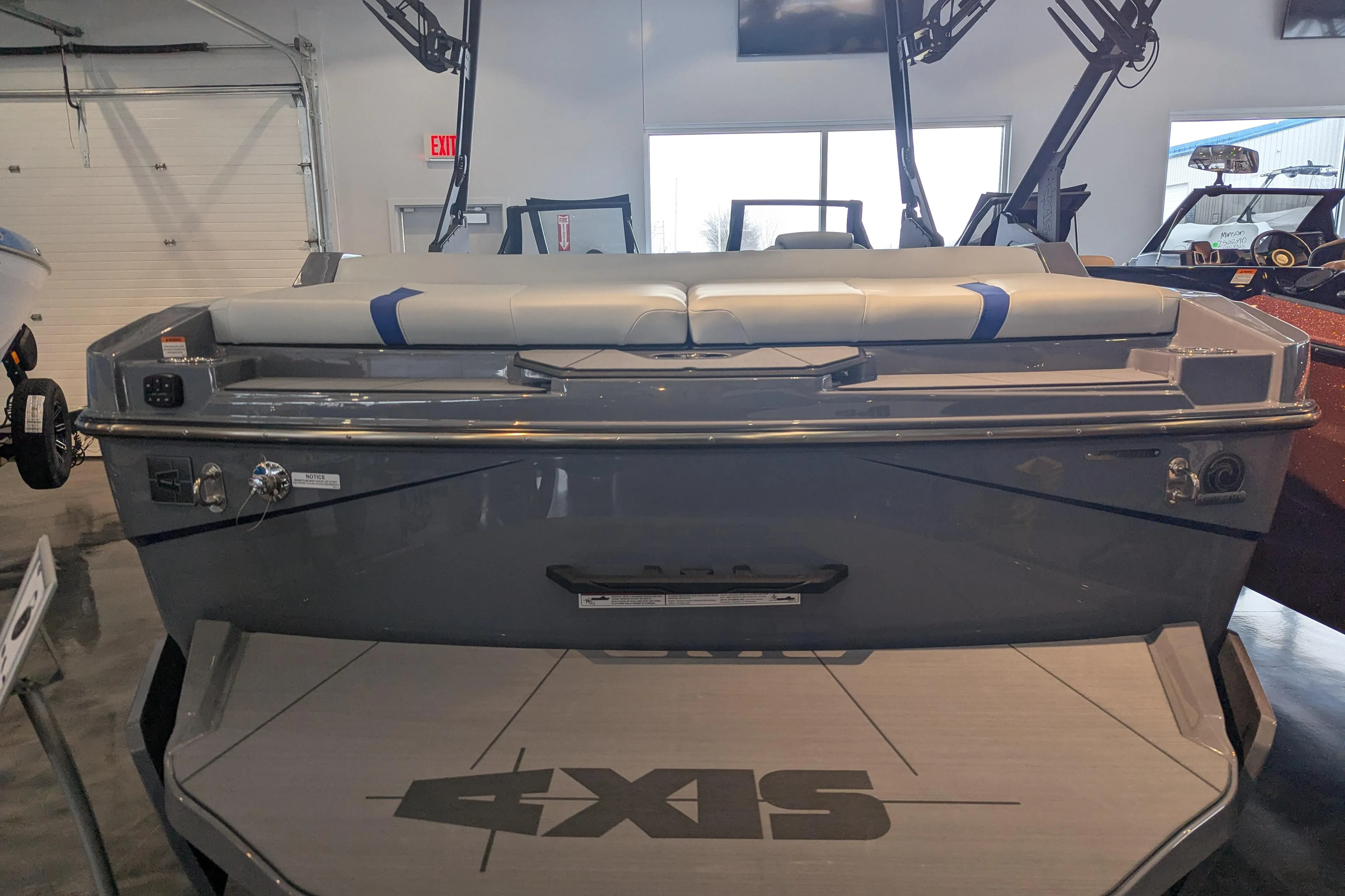 2025 Axis T220 boat in showroom, rear view with seating and logo visible.