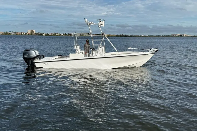  Yacht Photos Pics 2023 T Craft 27 boat on calm water with a person onboard.