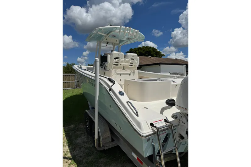  Yacht Photos Pics 2024 Cobia 280 Center Console boat under a bright blue sky with fluffy clouds.