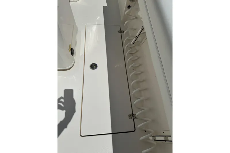  Yacht Photos Pics 2024 Cobia 280 Center Console deck with storage compartment and rod holders.