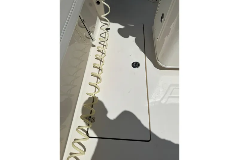  Yacht Photos Pics 2024 Cobia 280 Center Console deck with coiled hose and storage compartment.