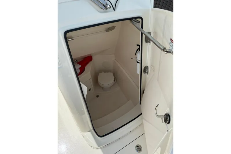  Yacht Photos Pics 2024 Cobia 280 Center Console boat interior with compact marine toilet and safety equipment.