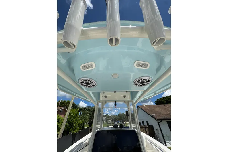  Yacht Photos Pics 2024 Cobia 280 Center Console boat with rod holders and speakers under blue canopy.
