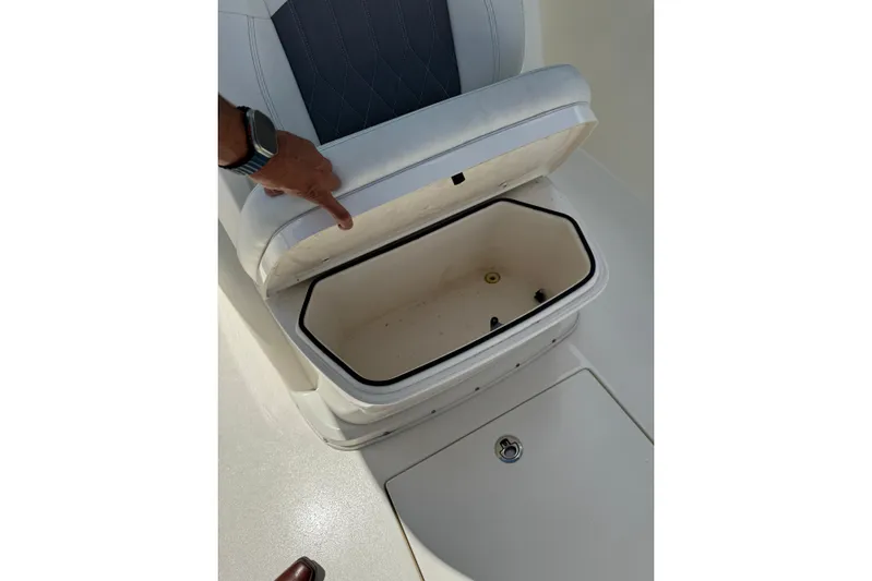  Yacht Photos Pics 2024 Cobia 280 Center Console seat storage compartment open, showcasing interior space.