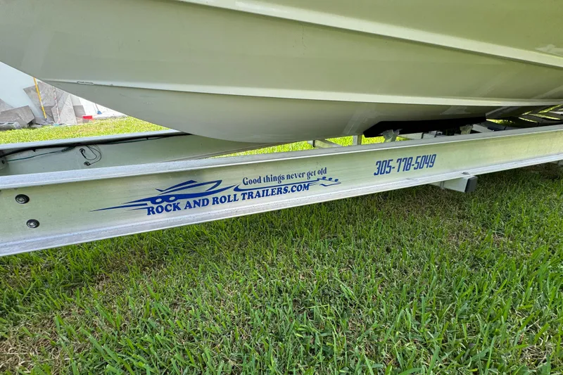  Yacht Photos Pics 2024 Cobia 280 Center Console on Rock and Roll trailer, parked on grass.