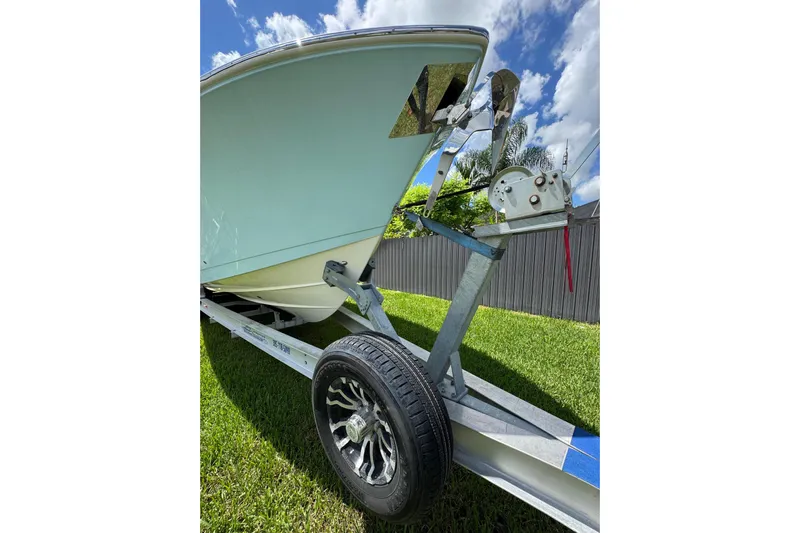  Yacht Photos Pics 2024 Cobia 280 Center Console boat on trailer, grassy yard, sunny day.