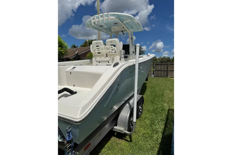  Yacht Photos Pics 2024 Cobia 280 Center Console boat on trailer, under clear blue sky.