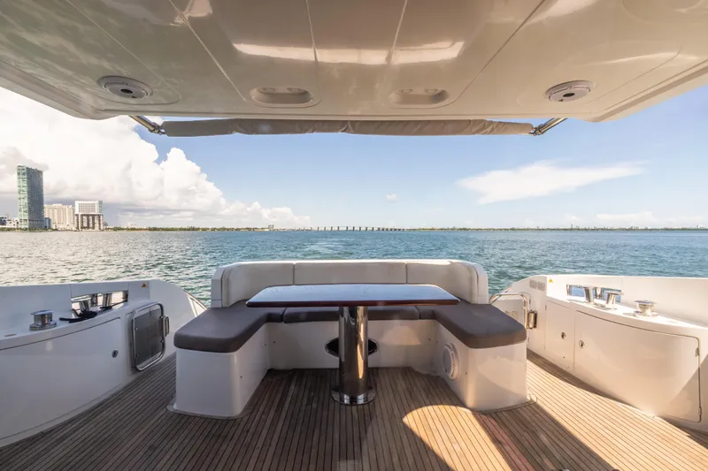 Prime Time II Yacht Photos Pics 2016 Azimut 64 Flybridge yacht deck with seating, overlooking ocean and city skyline.