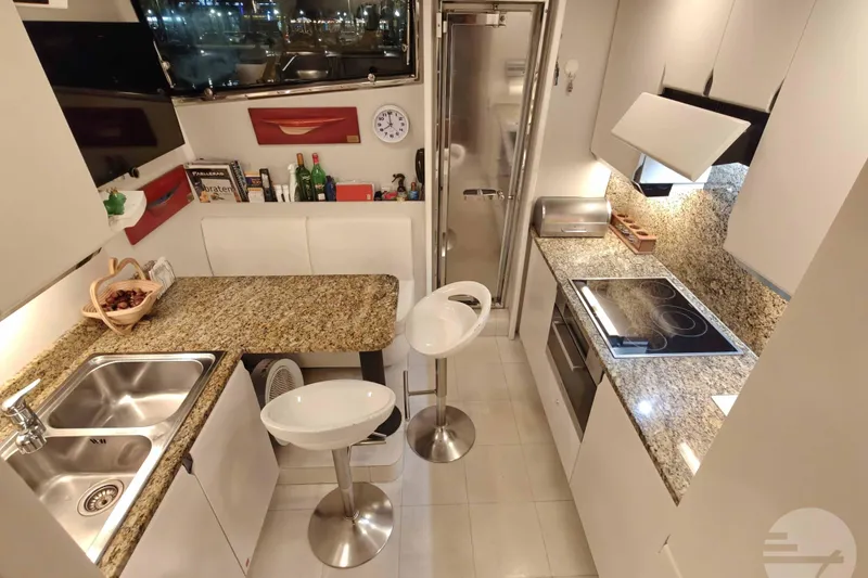  Yacht Photos Pics Luxurious kitchen interior of 1999 Sanlorenzo SL82 yacht with modern amenities and granite countertops.