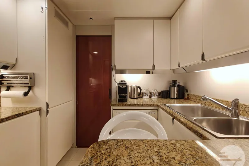  Yacht Photos Pics Luxurious kitchen interior of 1999 Sanlorenzo SL82 yacht with modern appliances and granite countertops.