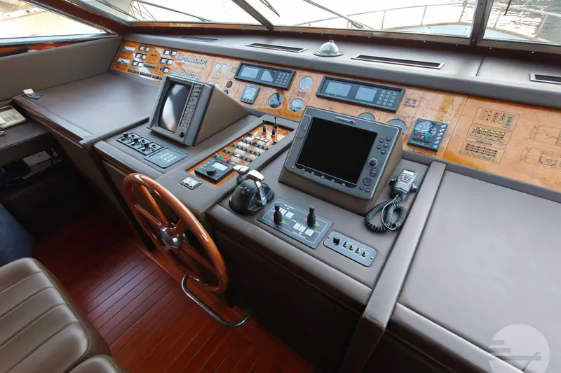  Yacht Photos Pics Cockpit of 1999 Sanlorenzo SL82 yacht with navigation instruments and wooden steering wheel.
