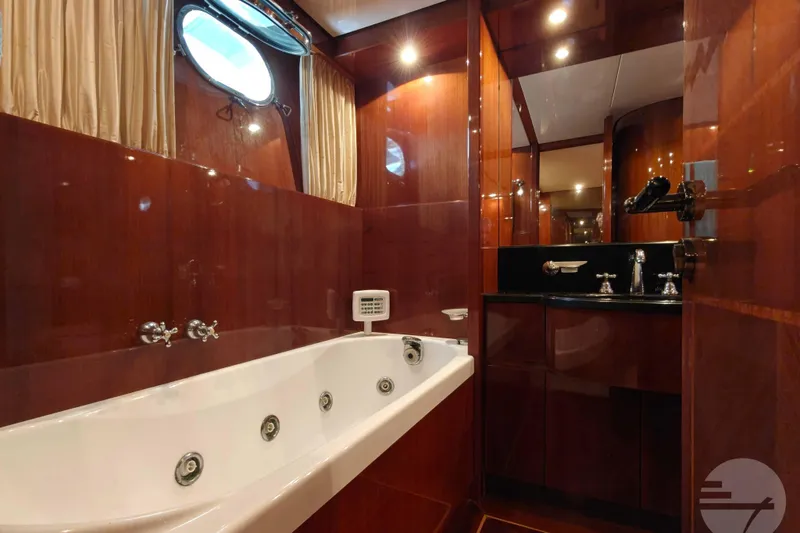  Yacht Photos Pics Luxurious bathroom with jacuzzi on 1999 Sanlorenzo SL82 yacht, featuring elegant wood paneling.