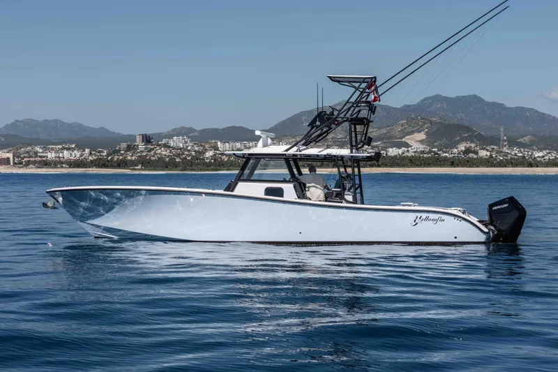  Yacht Photos Pics 2025 Yellowfin 42 Offshore boat on calm water with scenic mountain backdrop.