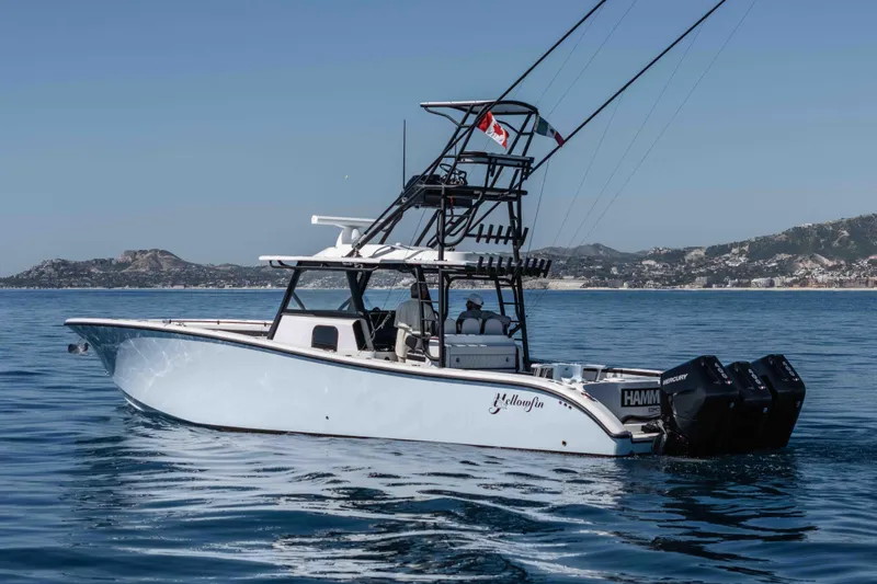  Yacht Photos Pics 2025 Yellowfin 42 Offshore boat on calm sea with scenic coastal background.