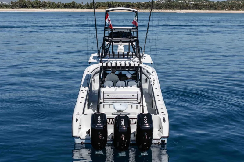  Yacht Photos Pics 2025 Yellowfin 42 Offshore boat with triple outboard engines on calm water.